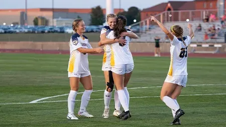 Women's soccer players celebrating.